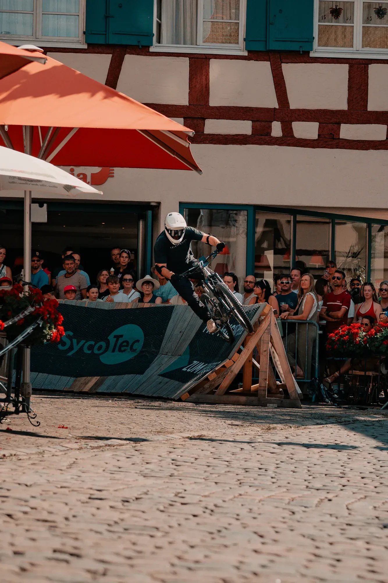 Fahrer im Wheelie auf dem Kopfsteinpflaster vor Fachwerkhäusern
